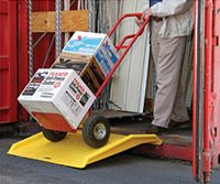 man loading boxes on a dolly with shipping container ramps