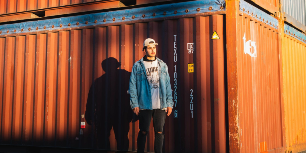 man standing next to shipping containers